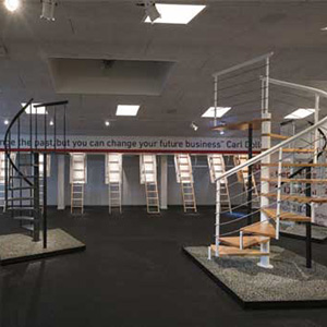 Foto interna do showroom da Dolle em 2018, apresentando diversos modelos e designs de escadas.